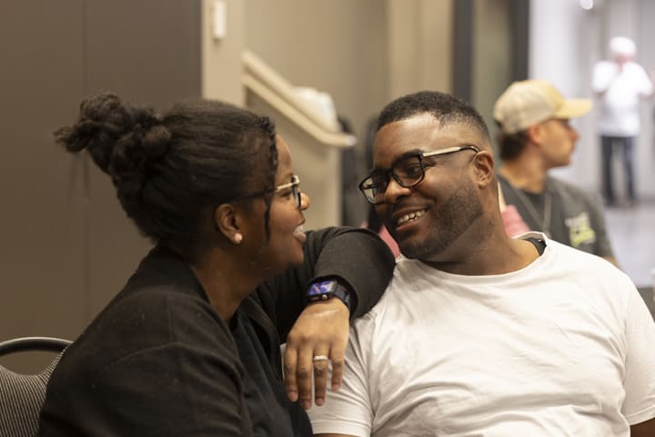 Deux membres de Nouvelle Vie échangent et sourient ensemble